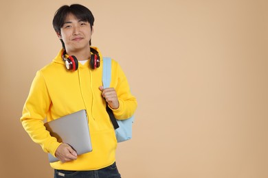 Photo of Student with laptop and backpack on beige background, space for text