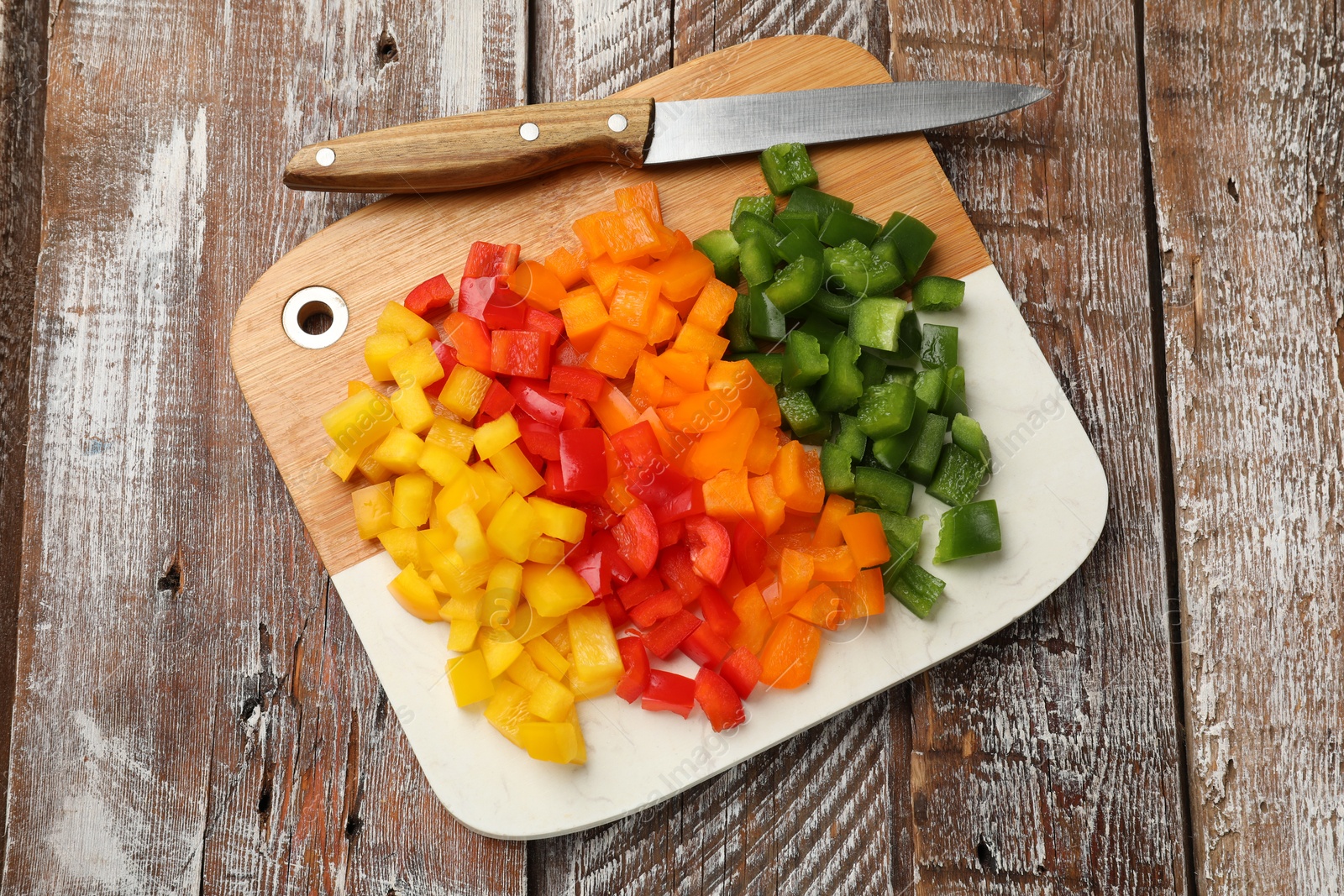 Cut colorful bell peppers on wooden table, top view Photo of Cut colorful bell peppers on wooden table, top view