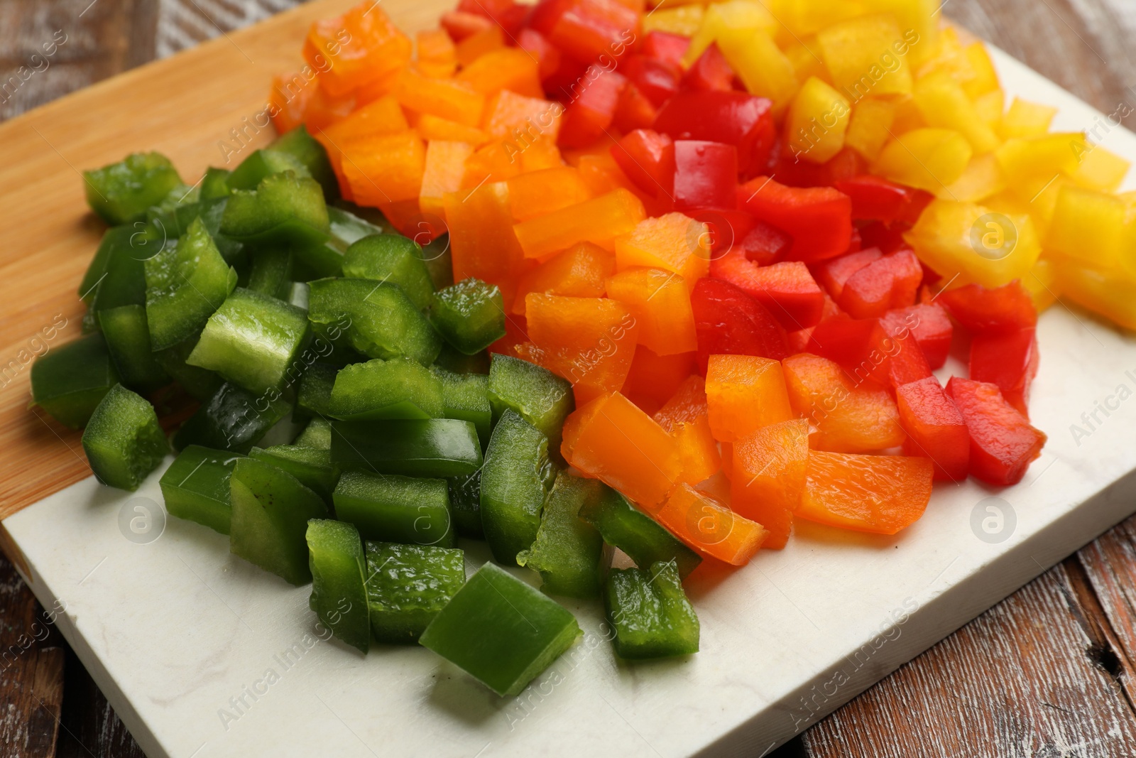 Cut colorful bell peppers on wooden table, closeup Photo of Cut colorful bell peppers on wooden table, closeup