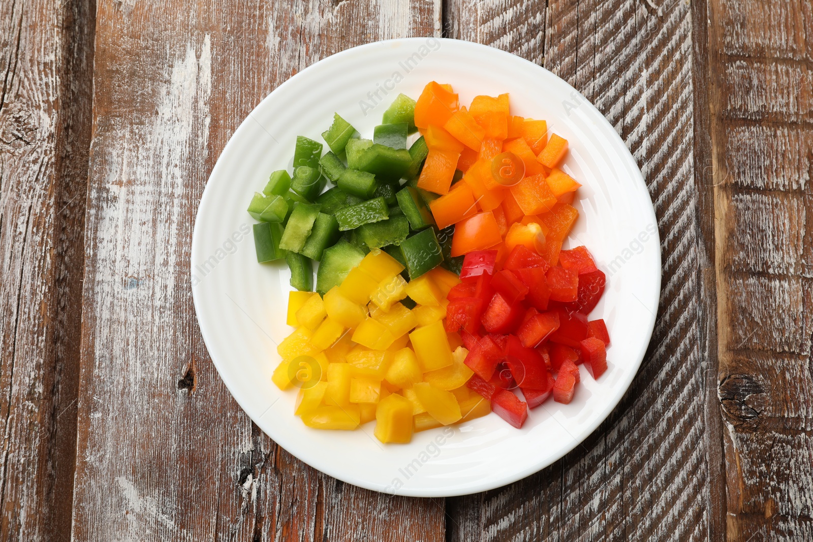 Cut colorful bell peppers on wooden table, top view Photo of Cut colorful bell peppers on wooden table, top view