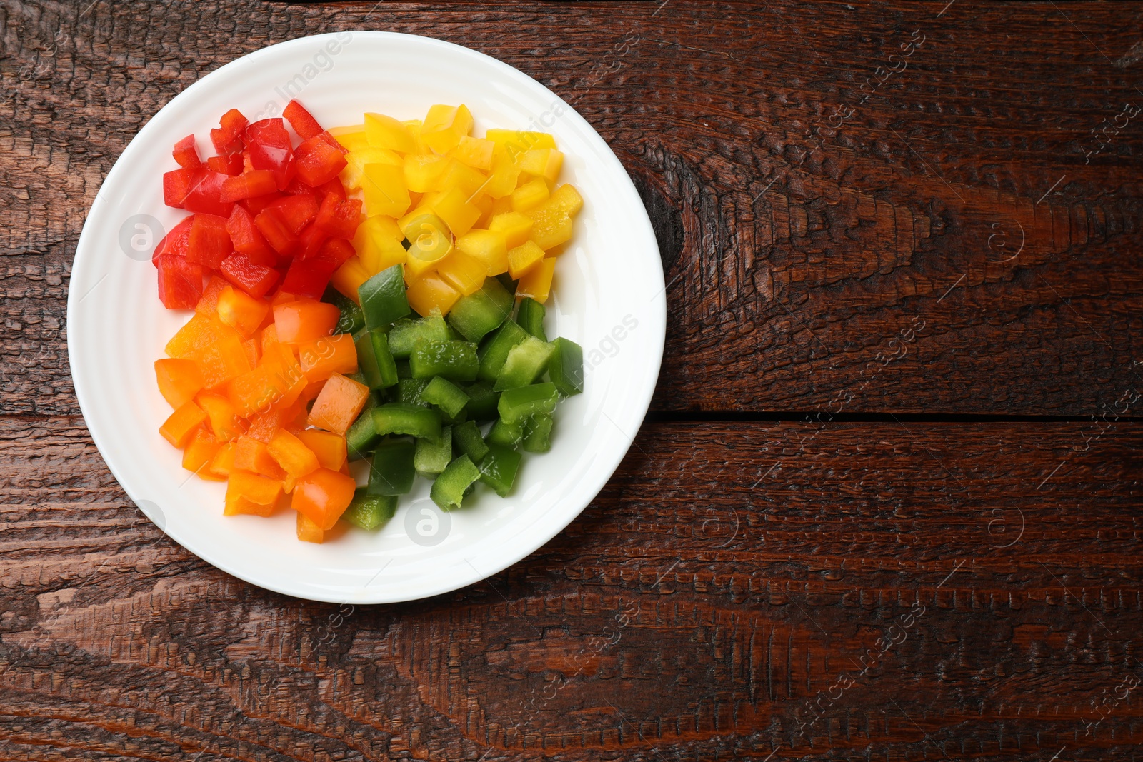 Cut colorful bell peppers on wooden table, top view. Space for text Photo of Cut colorful bell peppers on wooden table, top view. Space for text