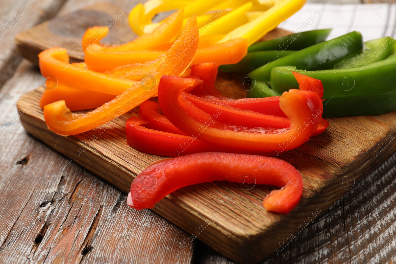Cut colorful bell peppers on wooden table, closeup Photo of Cut colorful bell peppers on wooden table, closeup