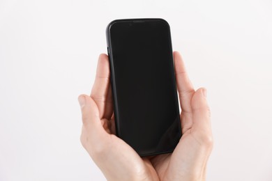 Photo of Woman holding smartphone with blank screen on white background, closeup. Mockup for design