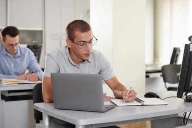 Photo of People studying at desks in library, selective focus