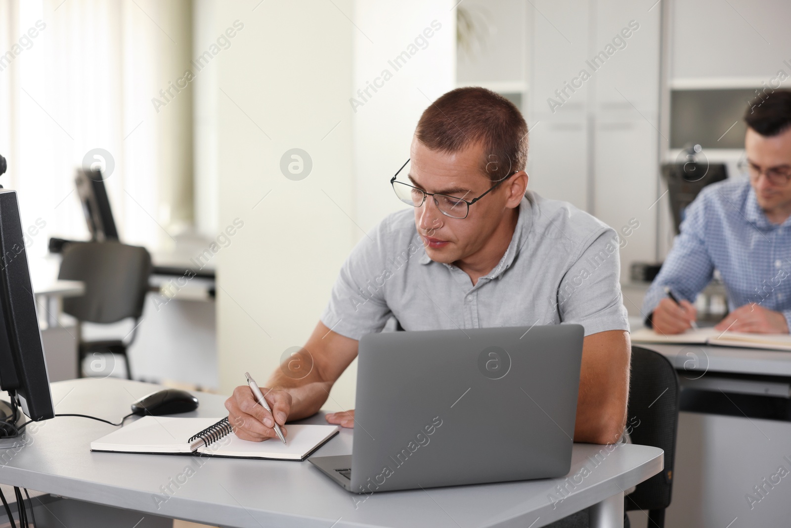 People studying at desks in library, selective focus Photo of People studying at desks in library, selective focus