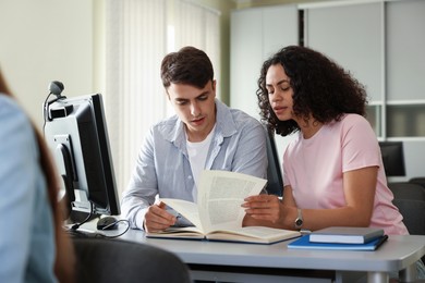 Photo of People studying together at desk in public library