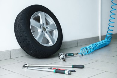 Photo of New tire and tools at car service