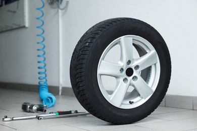 Photo of New tire and tools at car service