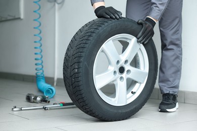 Photo of Mechanic changing tire at car service, closeup