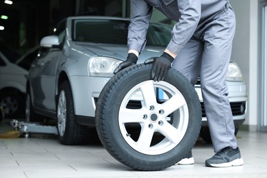 Photo of Mechanic changing tire at car service, closeup
