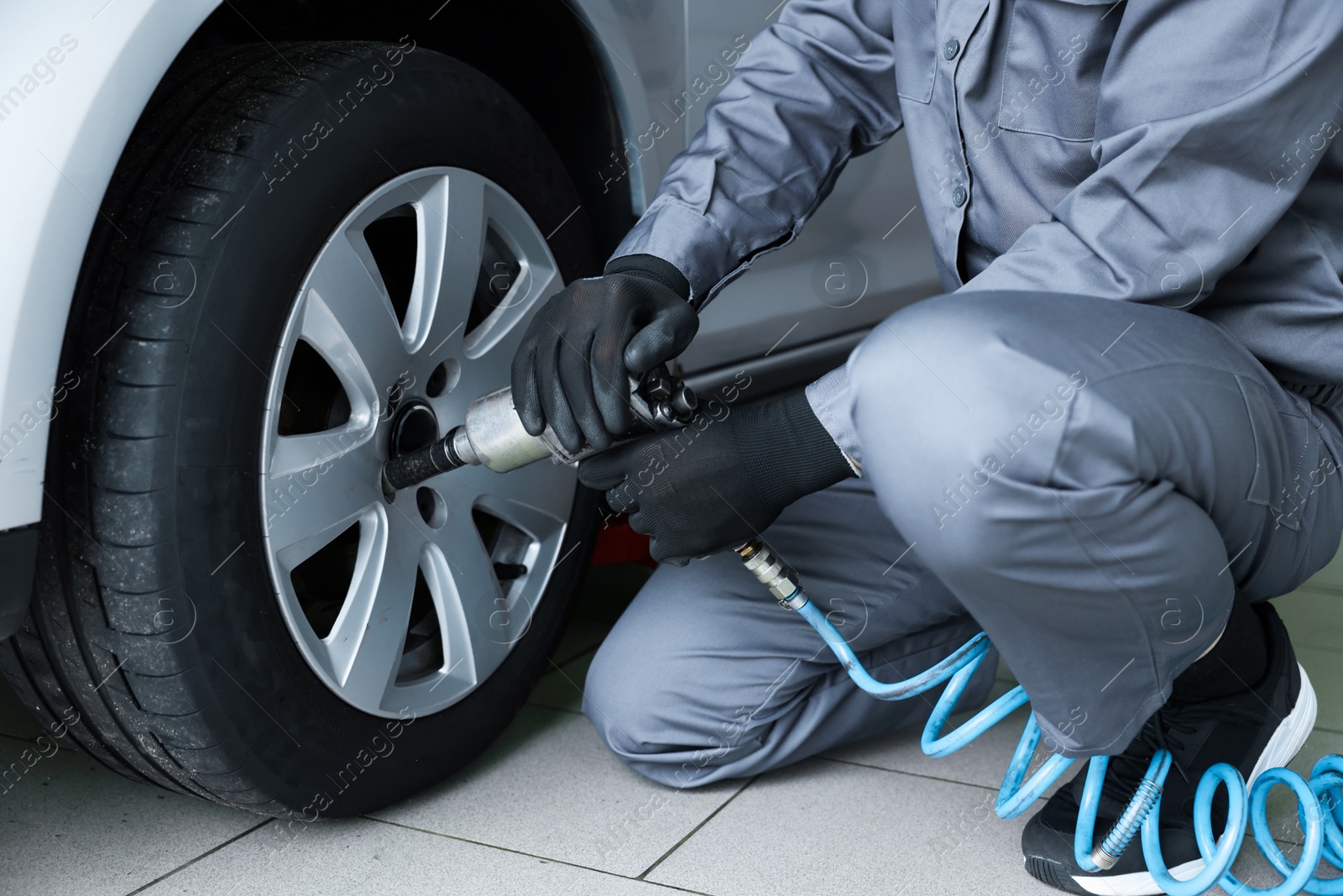 Mechanic changing tire at car service, closeup Photo of Mechanic changing tire at car service, closeup