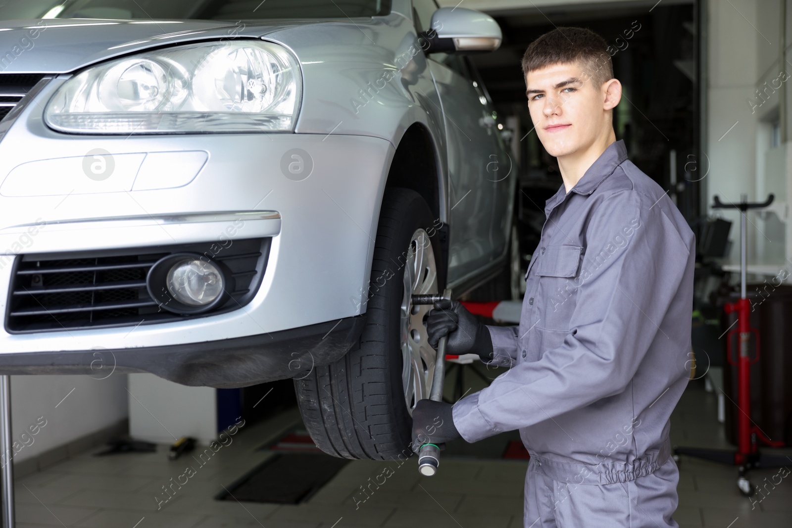 Professional mechanic changing tire at car service Photo of Professional mechanic changing tire at car service