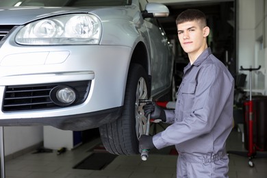 Photo of Professional mechanic changing tire at car service