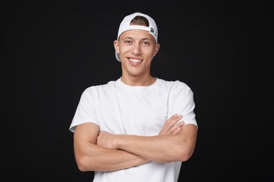 Photo of Young man wearing stylish white baseball hat on black background