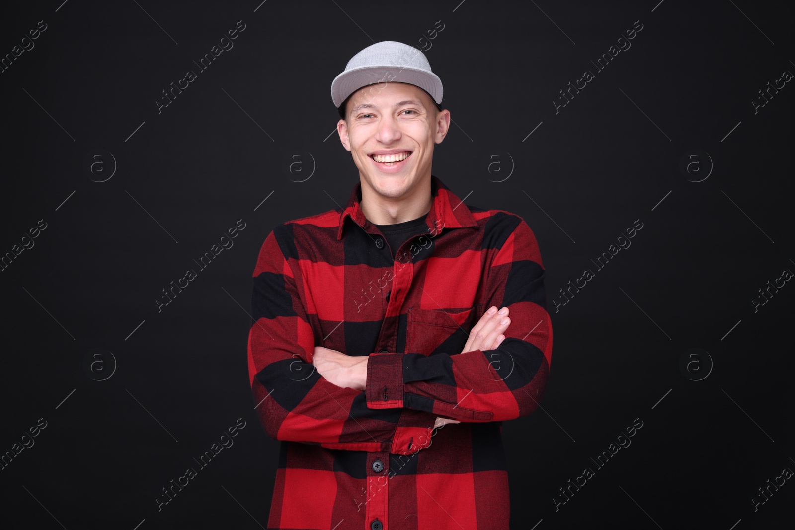 Photo of Young man wearing stylish baseball hat on black background