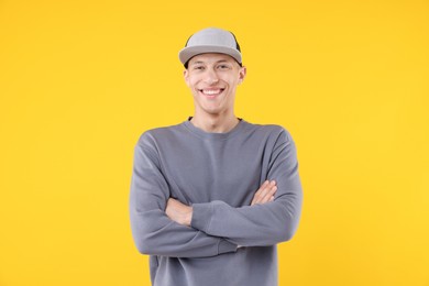 Photo of Young man wearing stylish baseball hat on yellow background