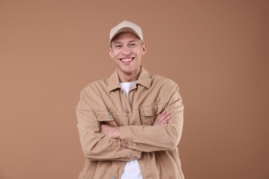 Photo of Young man wearing stylish beige baseball hat on light brown background