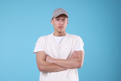 Photo of Young man wearing stylish grey baseball hat on light blue background