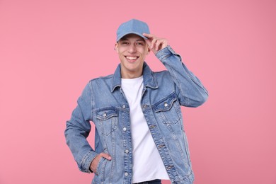 Photo of Young man wearing stylish denim baseball hat on pink background