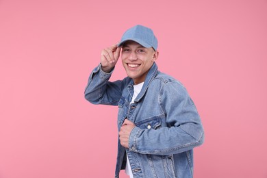 Photo of Young man wearing stylish denim baseball hat on pink background