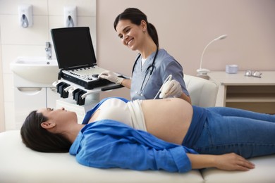 Photo of Sonographer conducting woman's prenatal ultrasound examination in clinic