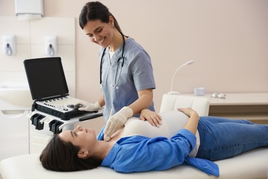Photo of Sonographer conducting ultrasound examination of pregnant woman's thyroid gland in clinic