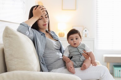 Photo of Woman suffering from postpartum depression with her little baby on sofa at home. Space for text
