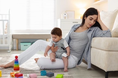 Photo of Woman suffering from postpartum depression with her little baby at home. Space for text