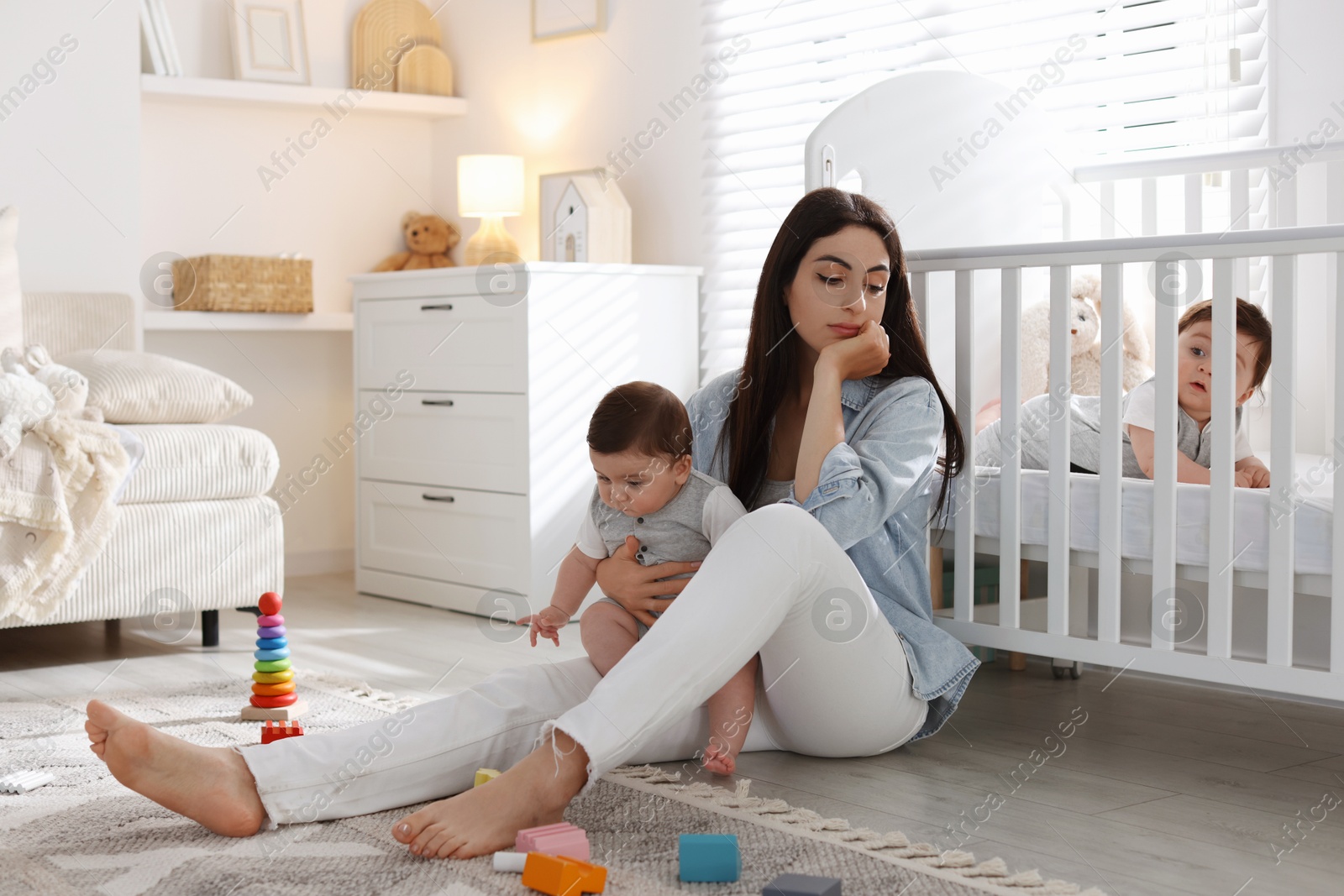 Woman suffering from postpartum depression with her little children at home. Space for text Photo of Woman suffering from postpartum depression with her little children at home. Space for text