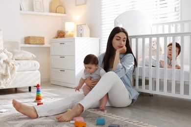 Photo of Woman suffering from postpartum depression with her little children at home. Space for text