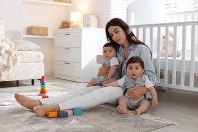 Photo of Woman suffering from postpartum depression with her little children at home. Space for text