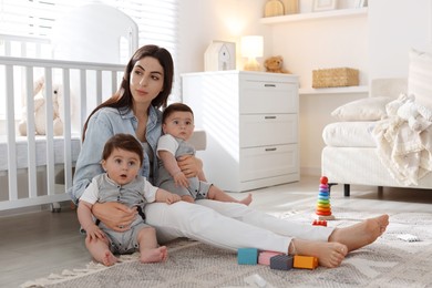 Photo of Woman suffering from postpartum depression with her little children at home. Space for text
