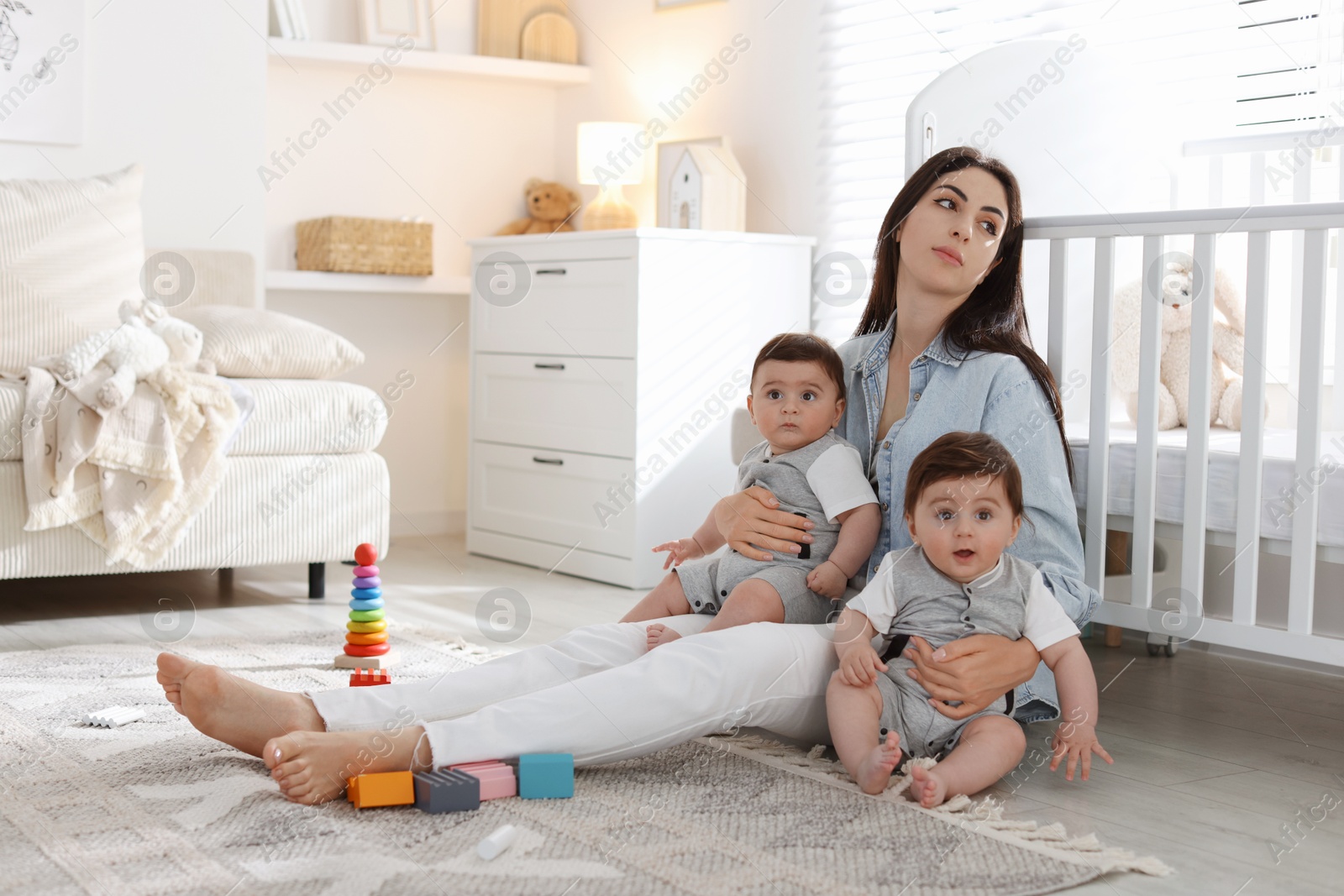 Woman suffering from postpartum depression with her little children at home. Space for text Photo of Woman suffering from postpartum depression with her little children at home. Space for text