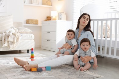 Photo of Woman suffering from postpartum depression with her little children at home. Space for text