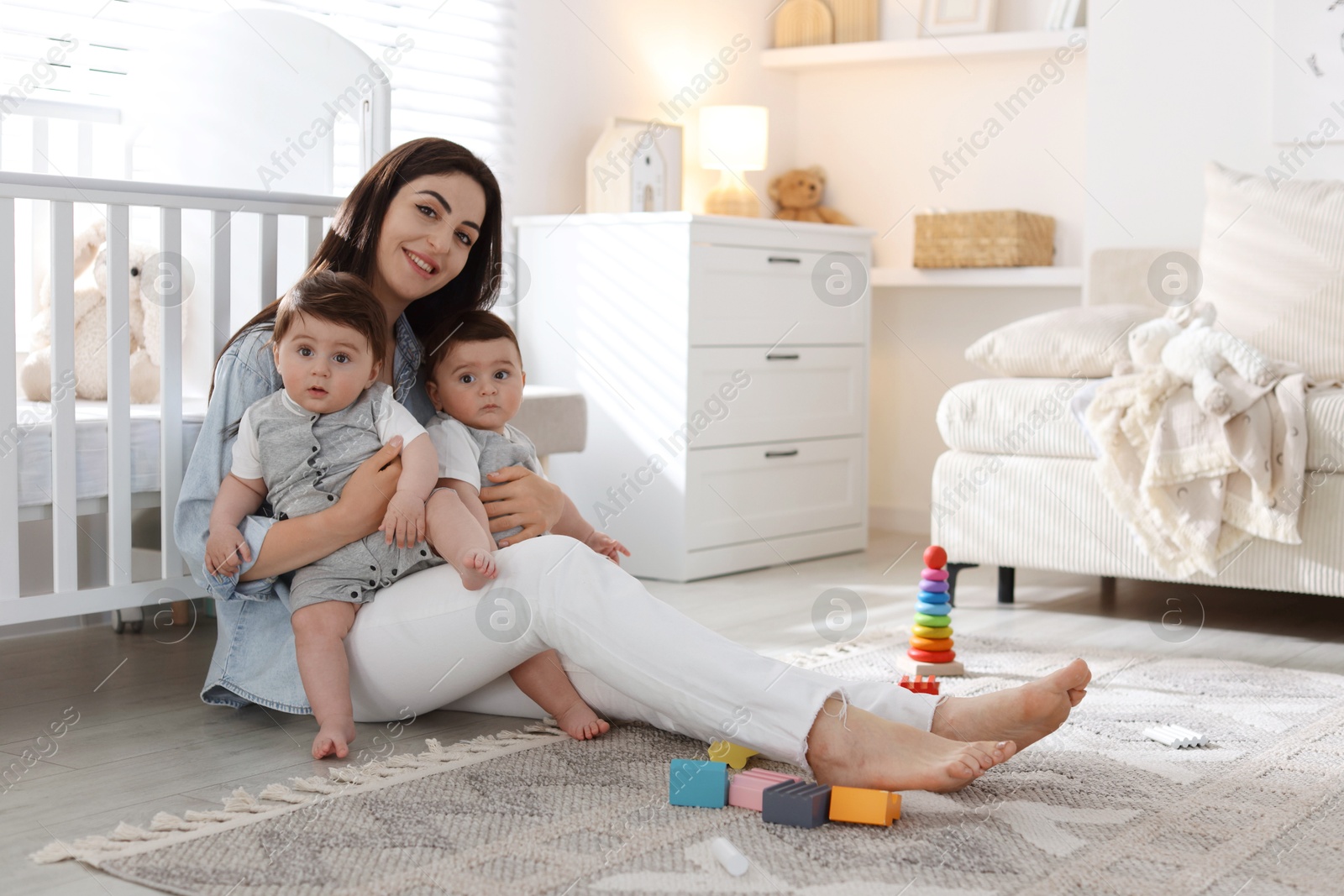 Photo of Mother with her cute twin babies at home