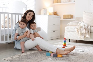 Photo of Mother with her cute twin babies at home