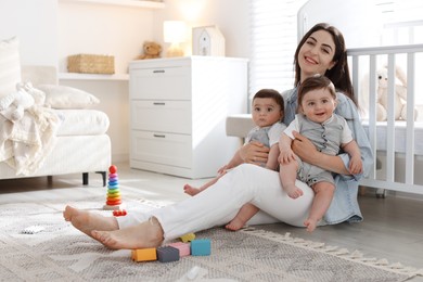 Photo of Mother with her cute twin babies at home