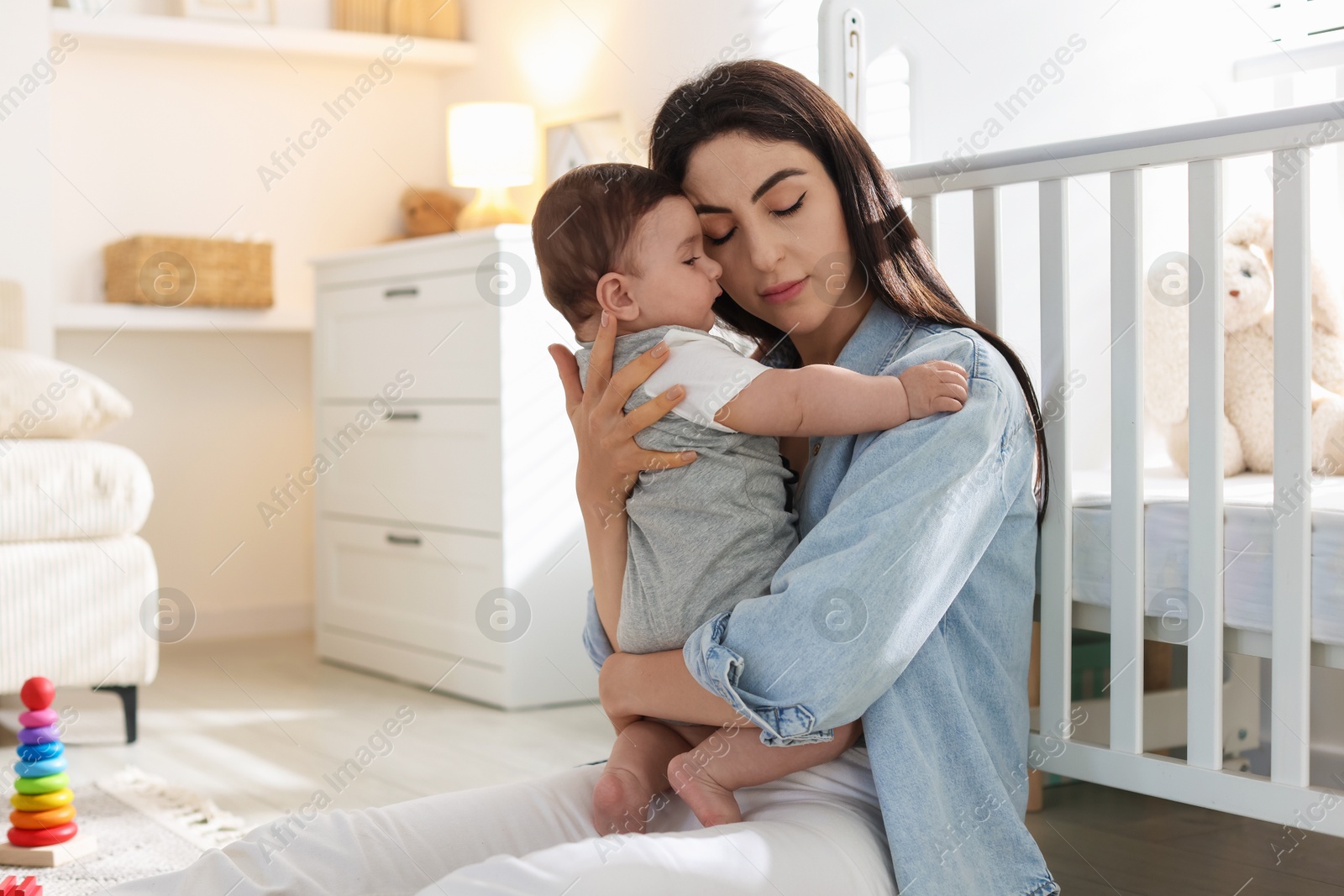 Woman suffering from postpartum depression with her little baby at home. Space for text Photo of Woman suffering from postpartum depression with her little baby at home. Space for text