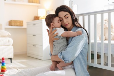 Photo of Woman suffering from postpartum depression with her little baby at home. Space for text
