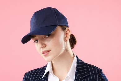 Photo of Portrait of beautiful woman in stylish baseball hat on pink background, closeup