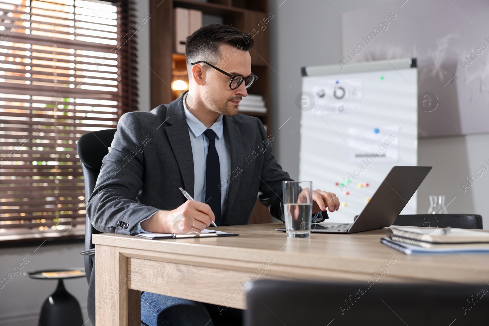Marketing. Man working at wooden desk in office Photo of Marketing. Man working at wooden desk in office