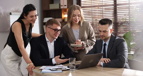 Photo of Marketing. Team of businesspeople working together at desk in office
