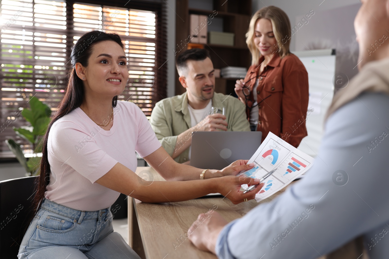 Photo of Marketing. Team of businesspeople working together at desk in office