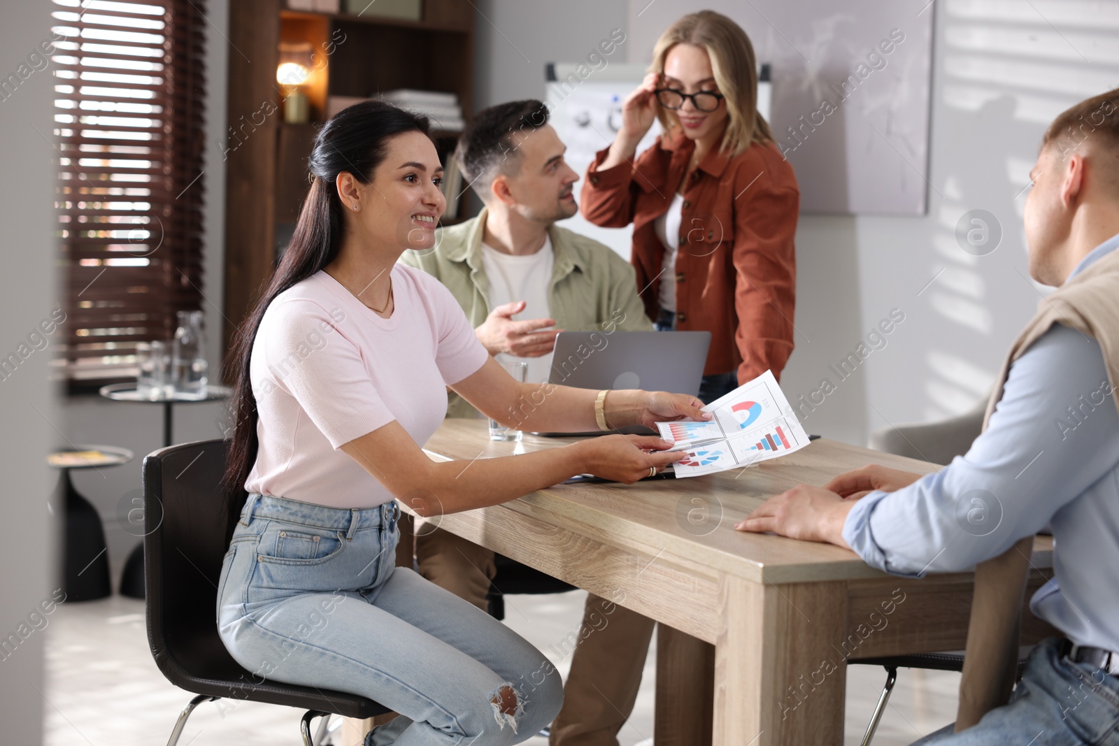 Marketing. Team of businesspeople working together at desk in office Photo of Marketing. Team of businesspeople working together at desk in office
