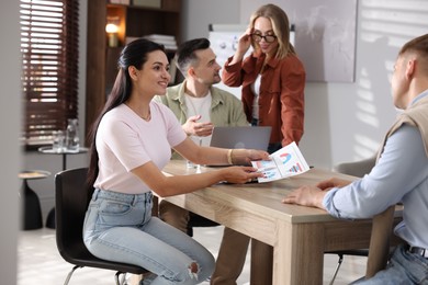 Photo of Marketing. Team of businesspeople working together at desk in office