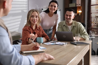 Photo of Marketing. Team of businesspeople working together at desk in office