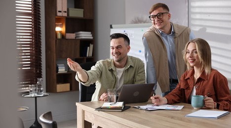 Photo of Marketing. Team of businesspeople working together at desk in office