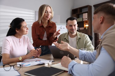 Photo of Marketing. Team of businesspeople working together at desk in office