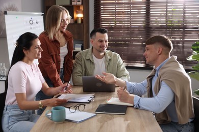Photo of Marketing. Team of businesspeople working together at desk in office