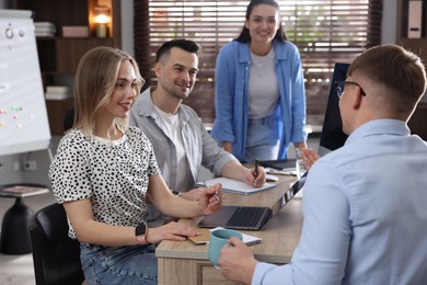 Photo of Marketing. Team of businesspeople working together at desk in office